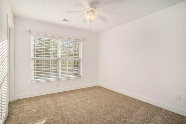 spare room with ceiling fan and carpet