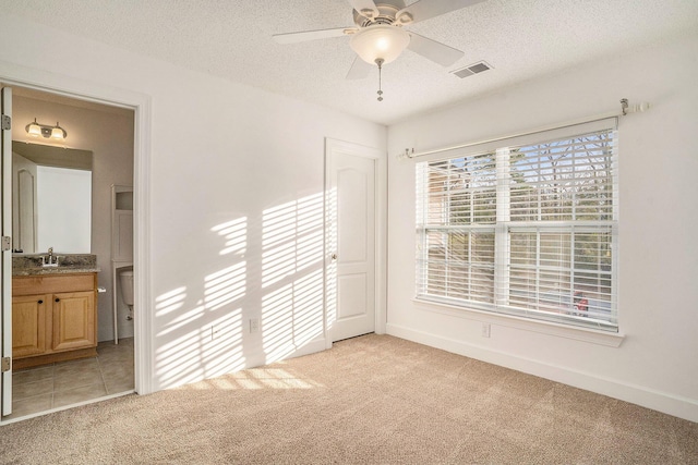 spare room featuring ceiling fan, light colored carpet, a textured ceiling, and sink