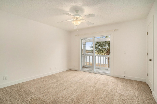 empty room with ceiling fan, a textured ceiling, and light carpet