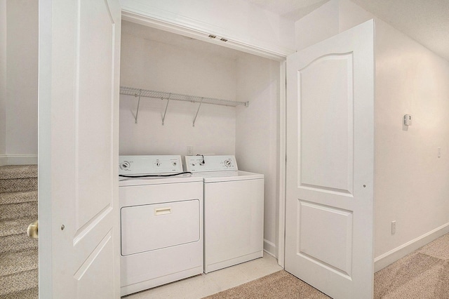 clothes washing area with light colored carpet and washer and dryer