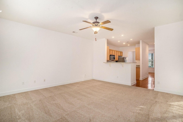 unfurnished living room with carpet flooring and ceiling fan