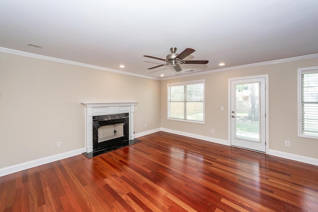 unfurnished living room featuring crown molding, plenty of natural light, and wood finished floors