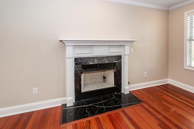 room details with baseboards, ornamental molding, wood finished floors, and a fireplace