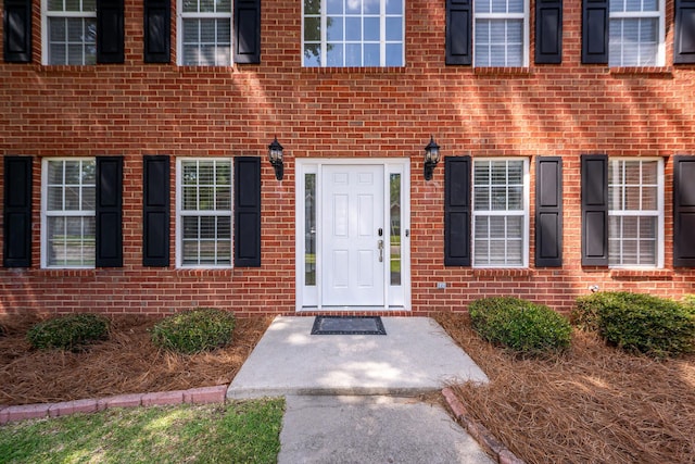 entrance to property featuring brick siding