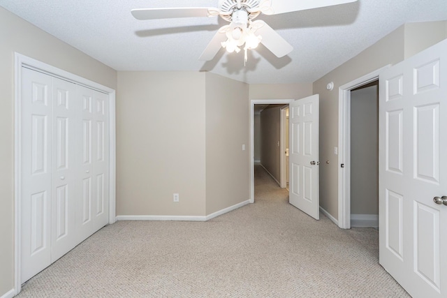 unfurnished bedroom with a ceiling fan, baseboards, light carpet, and a closet