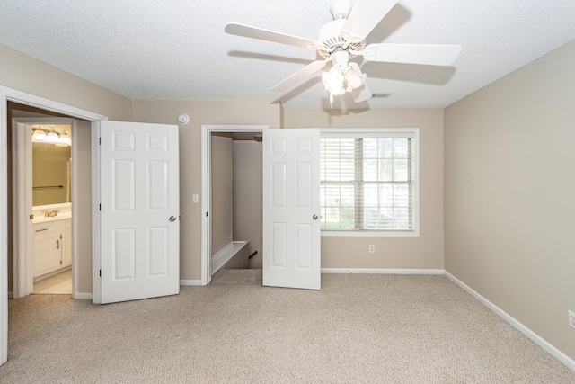 unfurnished bedroom featuring a ceiling fan, visible vents, a sink, baseboards, and light carpet