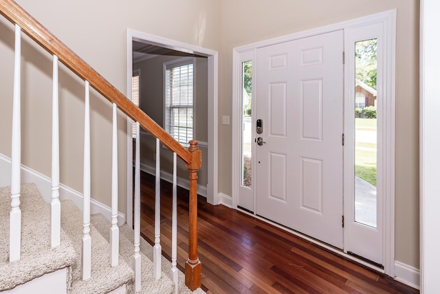 foyer featuring baseboards, stairs, and dark wood-type flooring