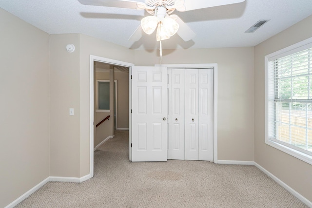 unfurnished bedroom featuring baseboards, visible vents, and light carpet