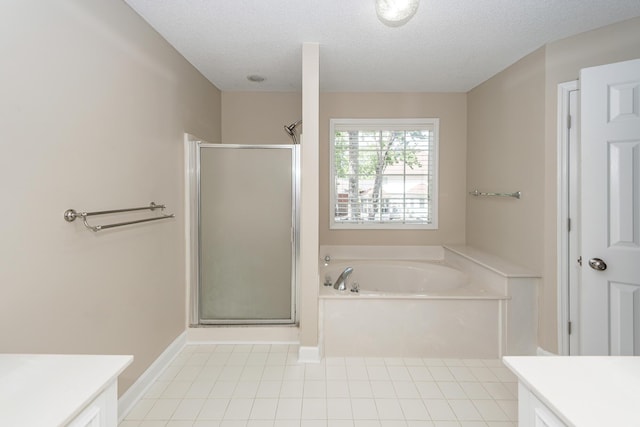 bathroom with vanity, a bath, a textured ceiling, and a stall shower