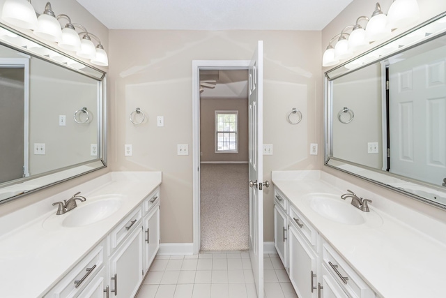 bathroom with baseboards, two vanities, and a sink