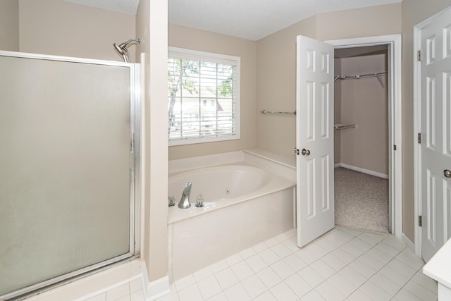 full bathroom with a garden tub, a walk in closet, tile patterned flooring, and a shower stall
