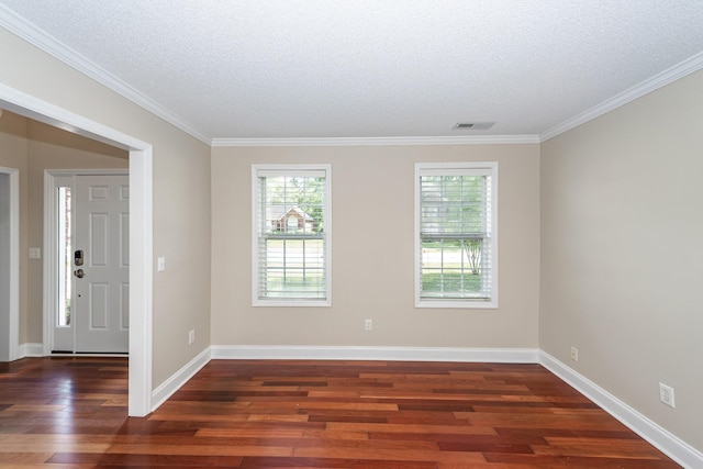 unfurnished room with visible vents, a textured ceiling, crown molding, and wood finished floors