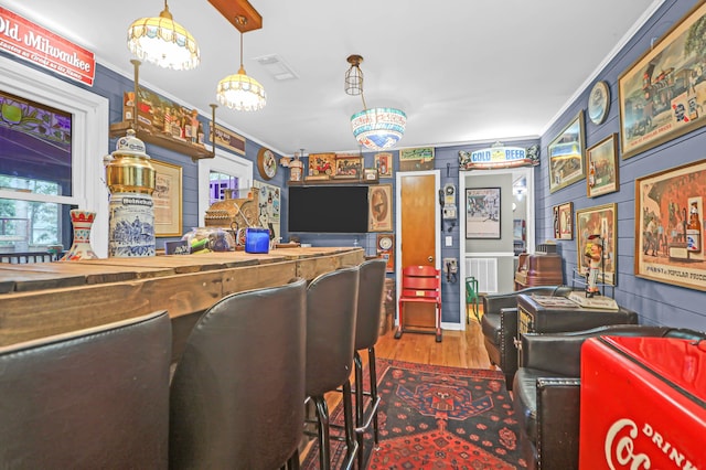 interior space with hardwood / wood-style flooring, ornamental molding, and a notable chandelier