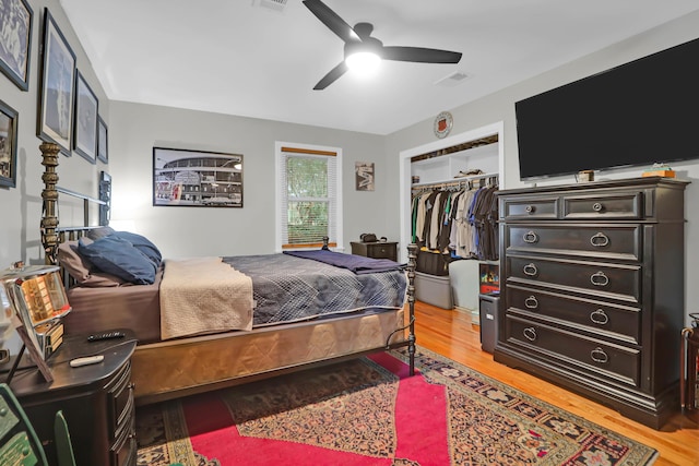 bedroom with a closet, hardwood / wood-style flooring, and ceiling fan