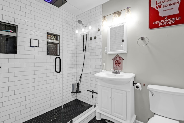 bathroom with toilet, a shower with shower door, and vanity