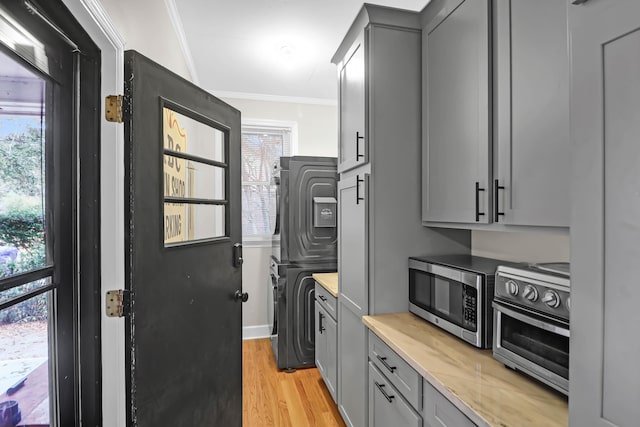 kitchen featuring gray cabinetry, ornamental molding, and light hardwood / wood-style flooring