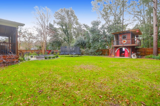 view of yard with a sunroom and a trampoline