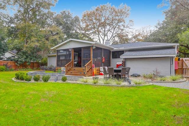 view of front facade with a front yard, a patio area, and a sunroom