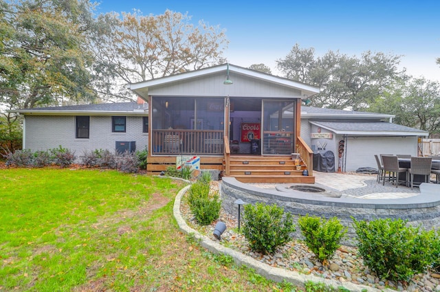 rear view of property with a patio area, a yard, and a sunroom