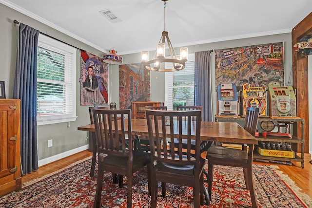 dining space with plenty of natural light, hardwood / wood-style floors, and an inviting chandelier