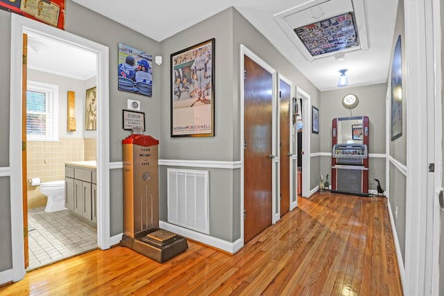 hall featuring tile walls and light wood-type flooring