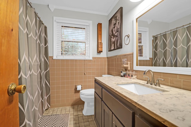 bathroom featuring toilet, vanity, tile walls, tile patterned floors, and crown molding