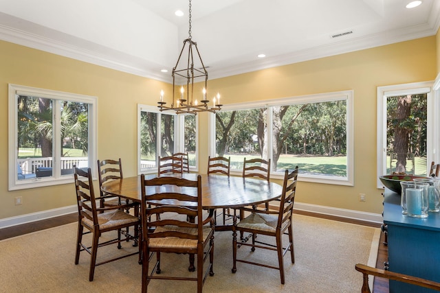 dining space featuring ornamental molding, hardwood / wood-style floors, and a notable chandelier