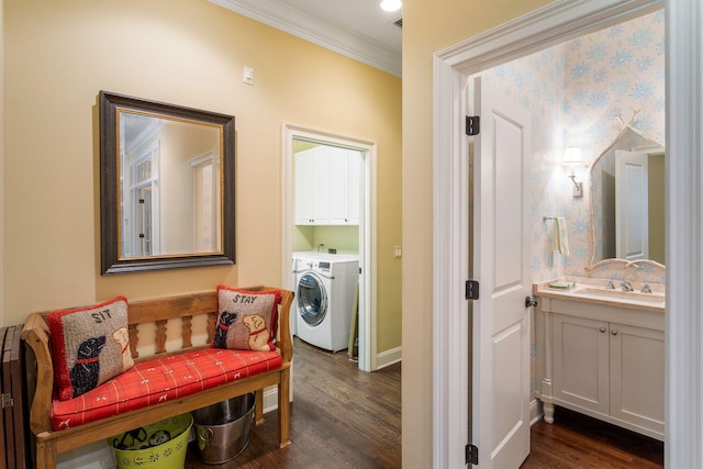 corridor with crown molding, washing machine and dryer, dark hardwood / wood-style floors, and sink