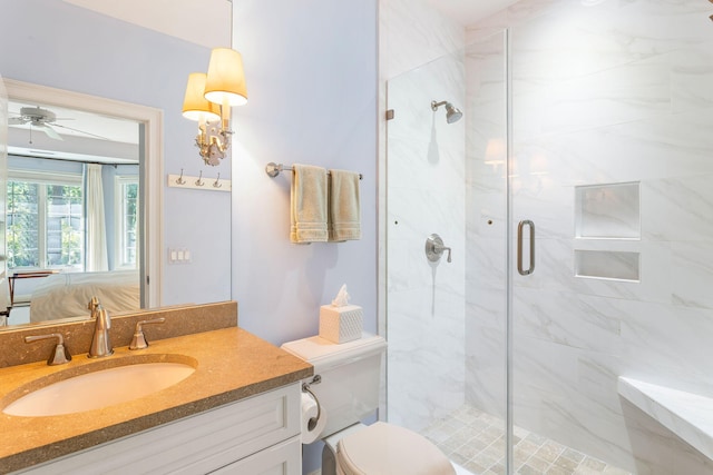 bathroom featuring ceiling fan, vanity, toilet, and a shower with door