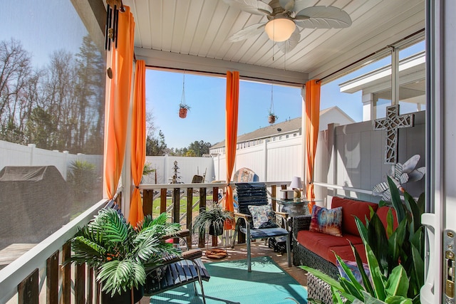 sunroom featuring a ceiling fan