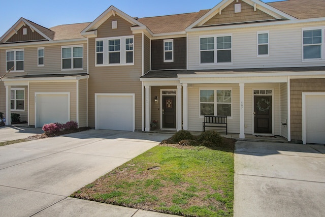 townhome / multi-family property with a porch, concrete driveway, and an attached garage