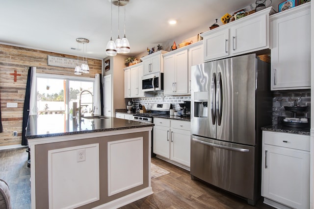 kitchen with a sink, stainless steel appliances, white cabinets, and decorative backsplash