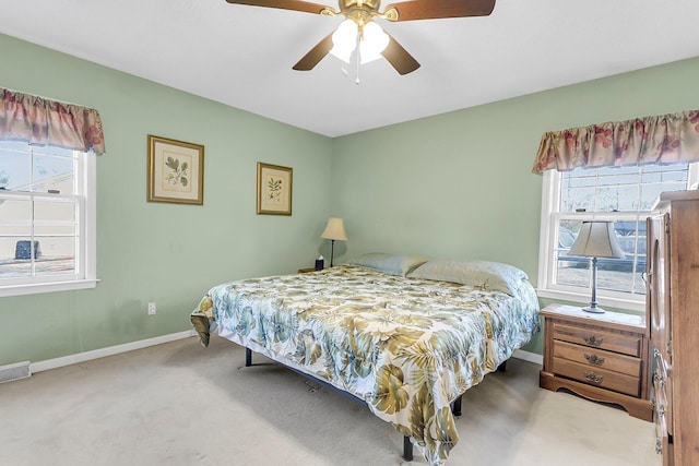 carpeted bedroom with multiple windows and ceiling fan