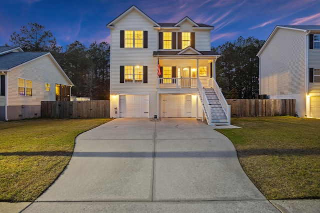 view of front of property with stairway, a front lawn, concrete driveway, and a garage