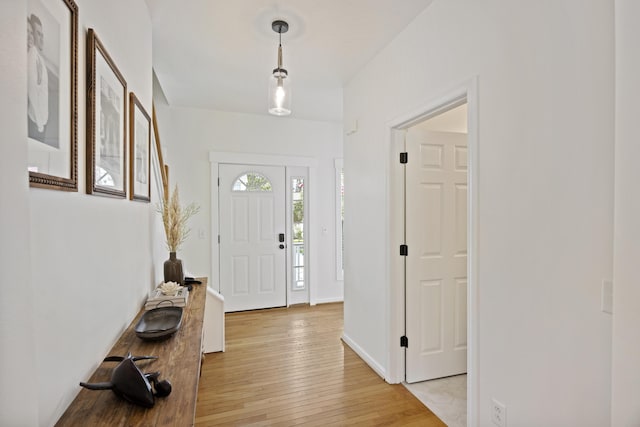 foyer with baseboards and light wood finished floors