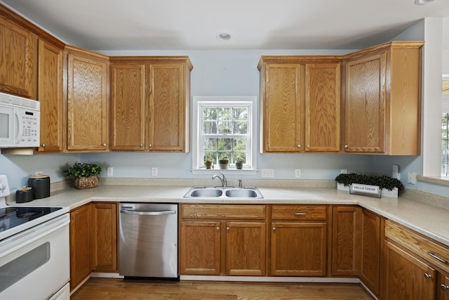 kitchen featuring recessed lighting, white appliances, light countertops, and a sink