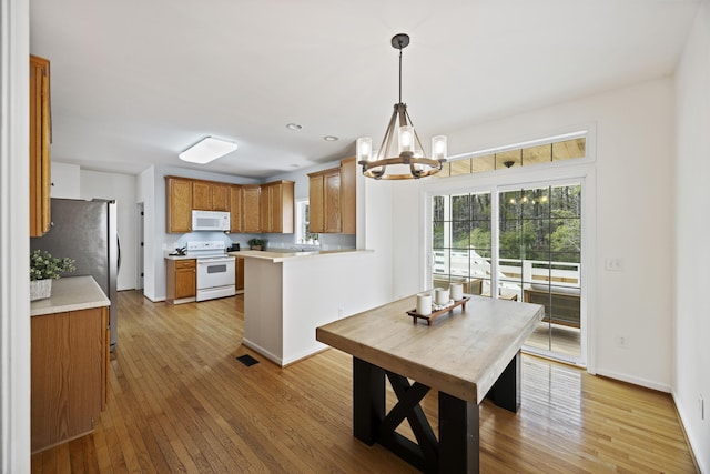 dining area with visible vents, recessed lighting, light wood-style floors, an inviting chandelier, and baseboards