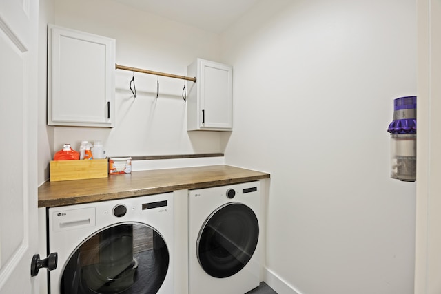 clothes washing area with washer and dryer and cabinet space