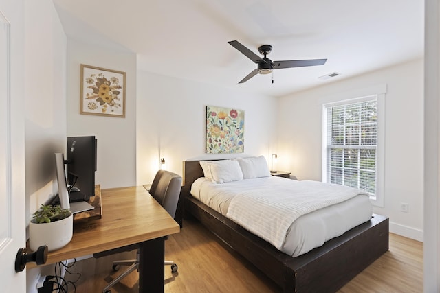 bedroom with light wood-style flooring, baseboards, visible vents, and ceiling fan