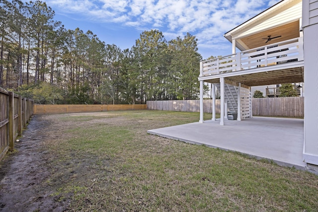 view of yard with a fenced backyard, a ceiling fan, stairs, and a patio