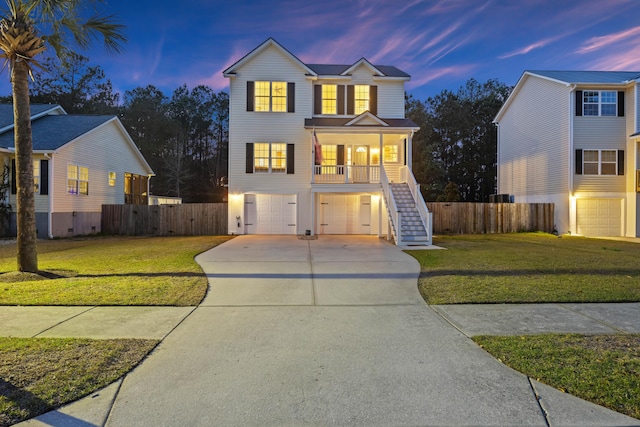 view of front of property featuring stairway, fence, a yard, concrete driveway, and a garage