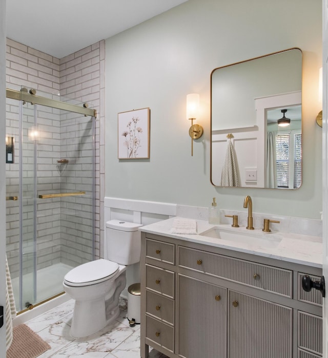 full bathroom with marble finish floor, a stall shower, vanity, and toilet