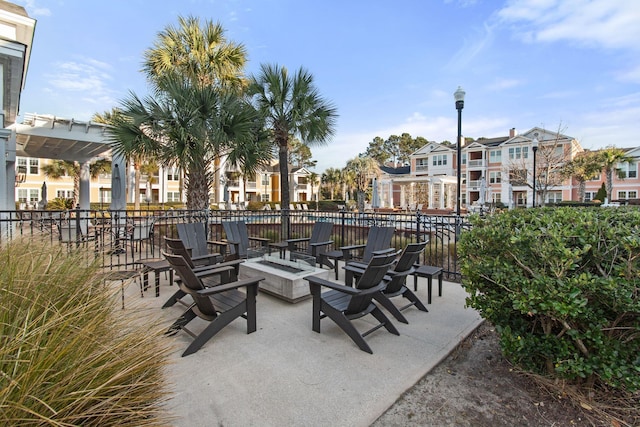 view of patio / terrace with a fire pit, fence, a residential view, and a pergola