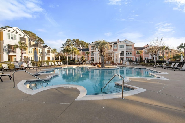 community pool featuring a residential view and a patio