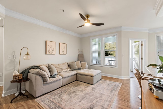 living room with crown molding, plenty of natural light, and light wood finished floors