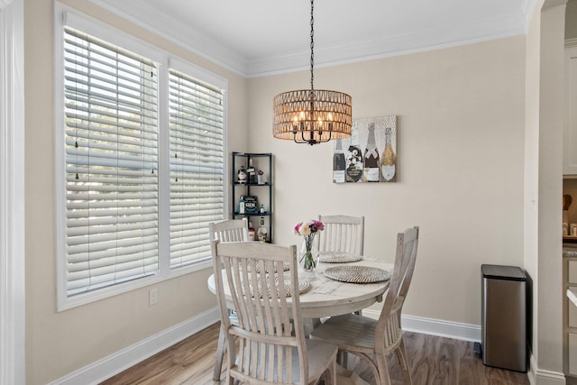 dining room with baseboards, a notable chandelier, wood finished floors, and crown molding