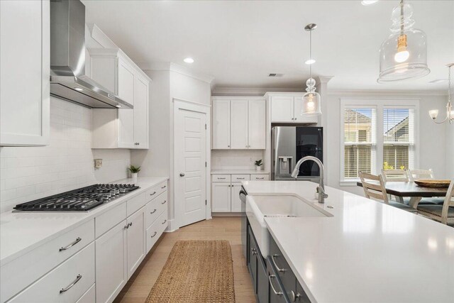 113 Grimball St, Summerville, SC 29486 - kitchen with wall chimney range hood, stainless steel appliances, a sink, light countertops, and white cabinetry