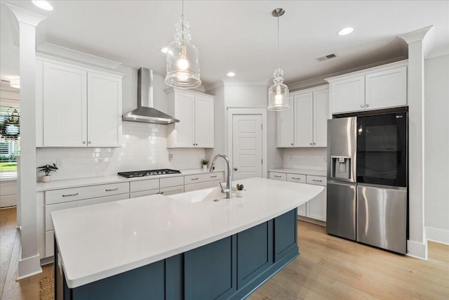 113 Grimball St, Summerville, SC 29486 - kitchen with stainless steel fridge, wall chimney exhaust hood, gas stovetop, a sink, and light wood finished floors