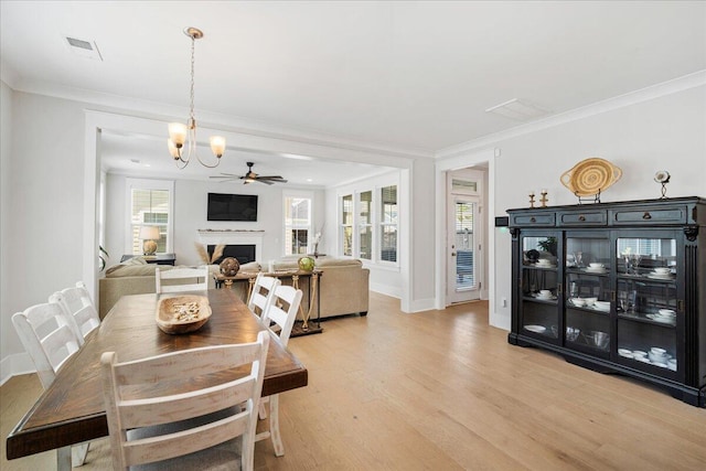 113 Grimball St, Summerville, SC 29486 - dining room with light wood finished floors, a fireplace, crown molding, baseboards, and a ceiling fan