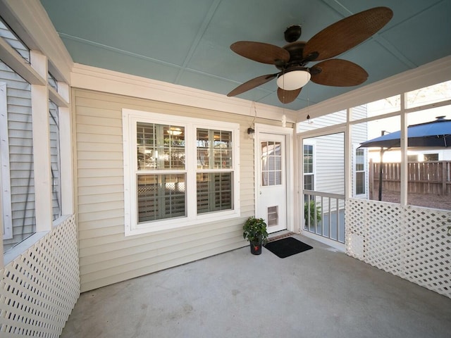 unfurnished sunroom with ceiling fan